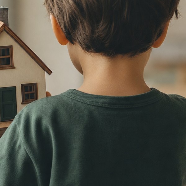 Young child holding toy house model — detail